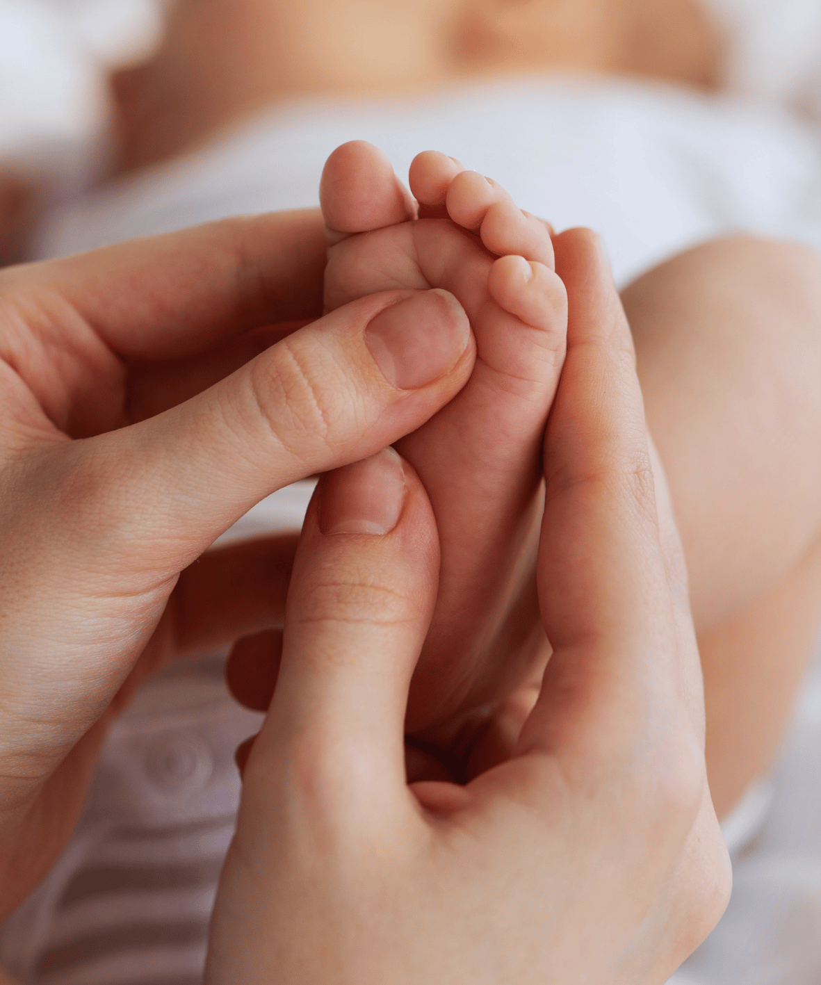 Gestes de réflexologie sur les pieds d'un bébé